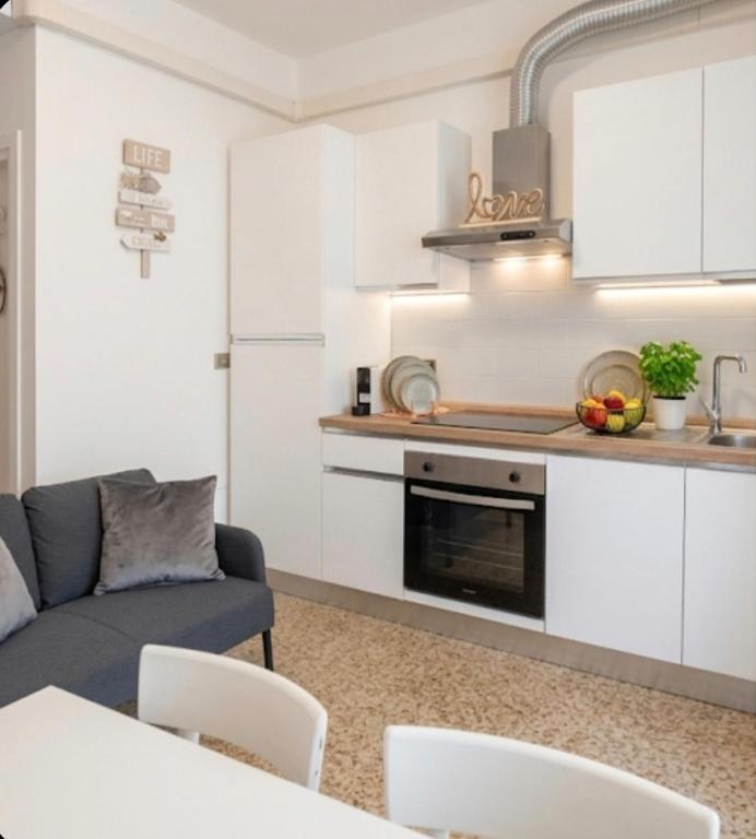 a living room with a couch and a kitchen at Appartamento estivo PONENTE - Misano Adriatico -RN- in Misano Adriatico