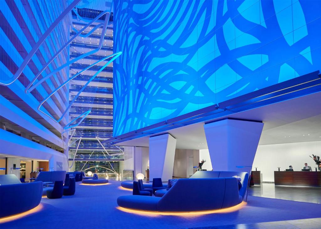 a lobby with blue chairs and a building at Conrad New York Downtown in New York