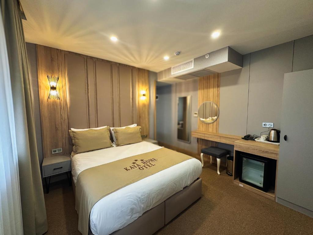 a hotel room with a large bed and a desk at Kaya Home Otel in Trabzon