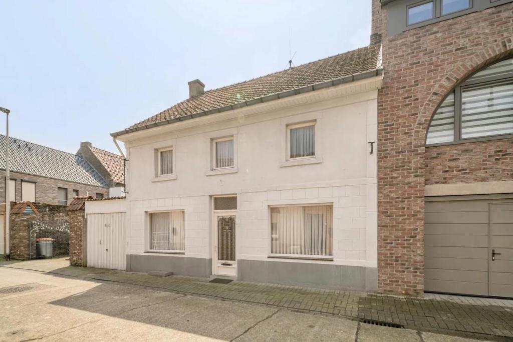 a white brick house with a garage at Vakantiewoning Goed Thuis in Dilsen-Stokkem