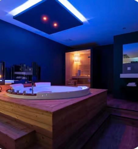 a large bathroom with a large tub with blue lighting at Loveroom Lens in Lens