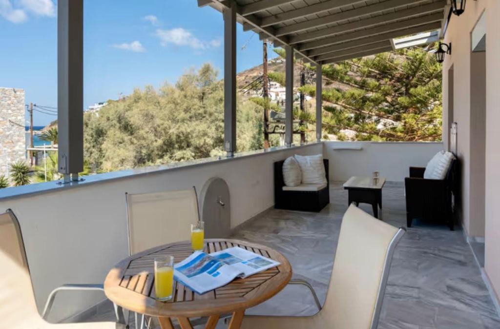 a patio with a table and chairs on a balcony at Sunset Realty in Ano Syros