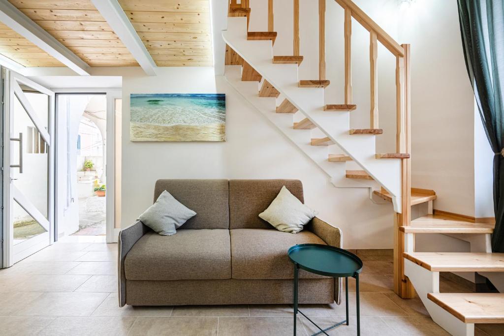 a living room with a couch and stairs at Respiro di Chiaia in Procida