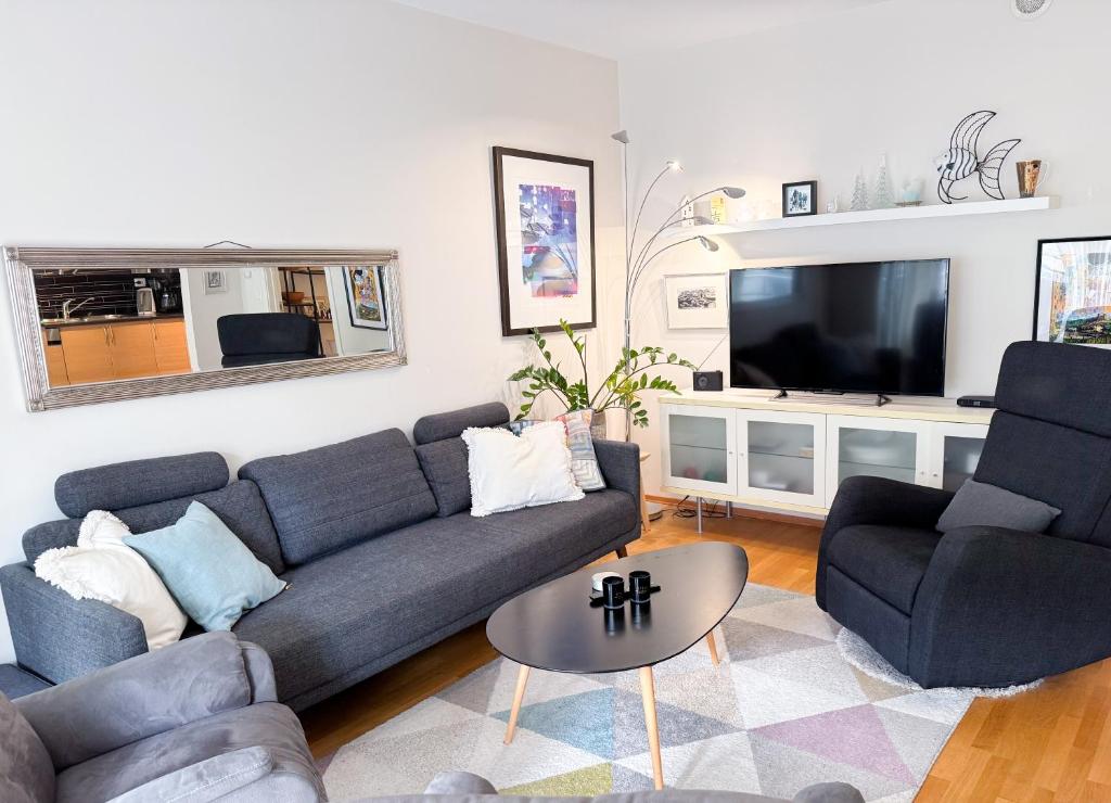 a living room with a couch and a tv at The Seabreeze Marina in Mandal