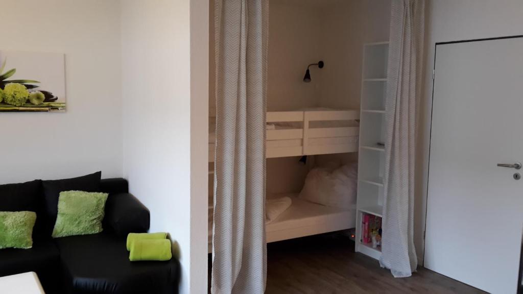 ein Wohnzimmer mit einem schwarzen Sofa und einem Schrank in der Unterkunft Ferienwohnung "kleines glück" in Winterberg-Niedersfeld in Winterberg