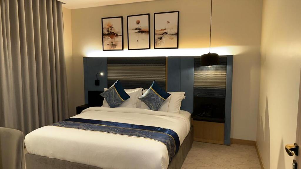 a bedroom with a large bed with blue and white pillows at فندق لامار بارك - العليا in Tabuk