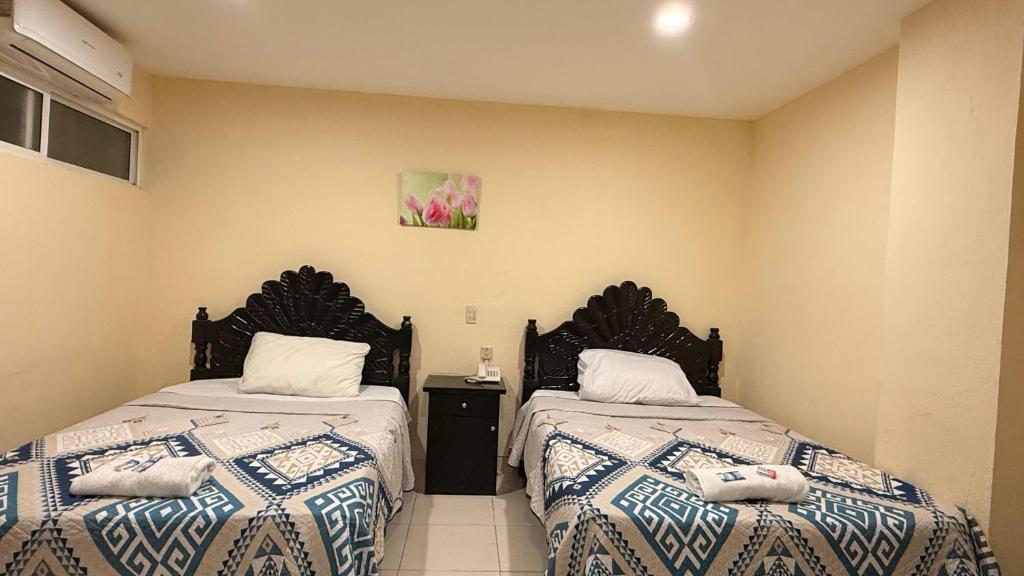 two beds sitting next to each other in a room at Hotel Boutique Los Laureles in Tuxtla Gutiérrez