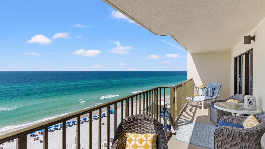 a balcony with chairs and a view of the ocean at Beachfront Breeze by AvantStay in Panama City Beach