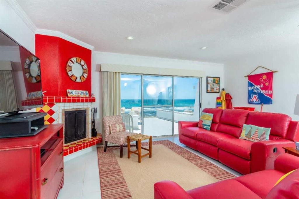 a living room with a red couch and a fireplace at Charming & Cozy Beachfront Condo Las Olas I 19 in Puerto Peñasco