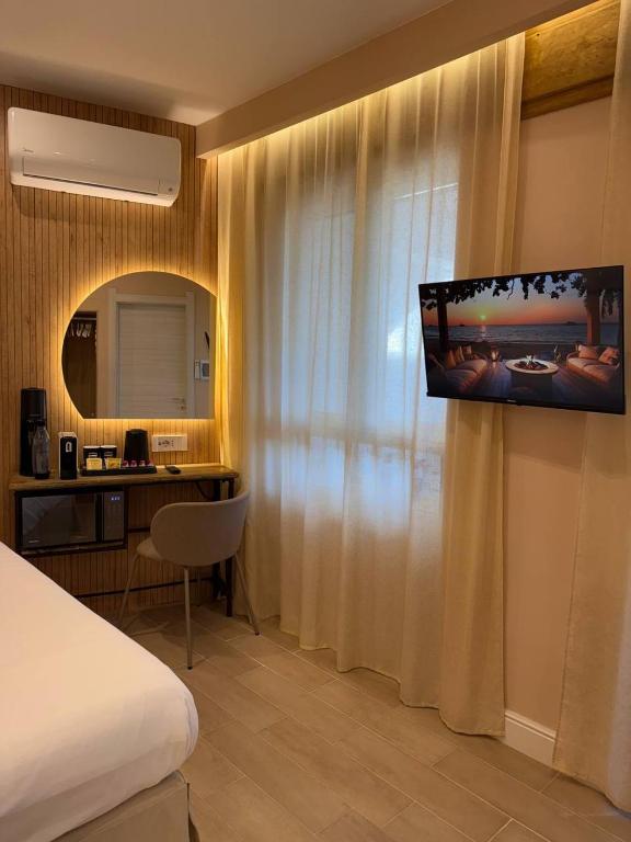a hotel room with a bed and a desk and a television at Windofsand Room in Cagliari