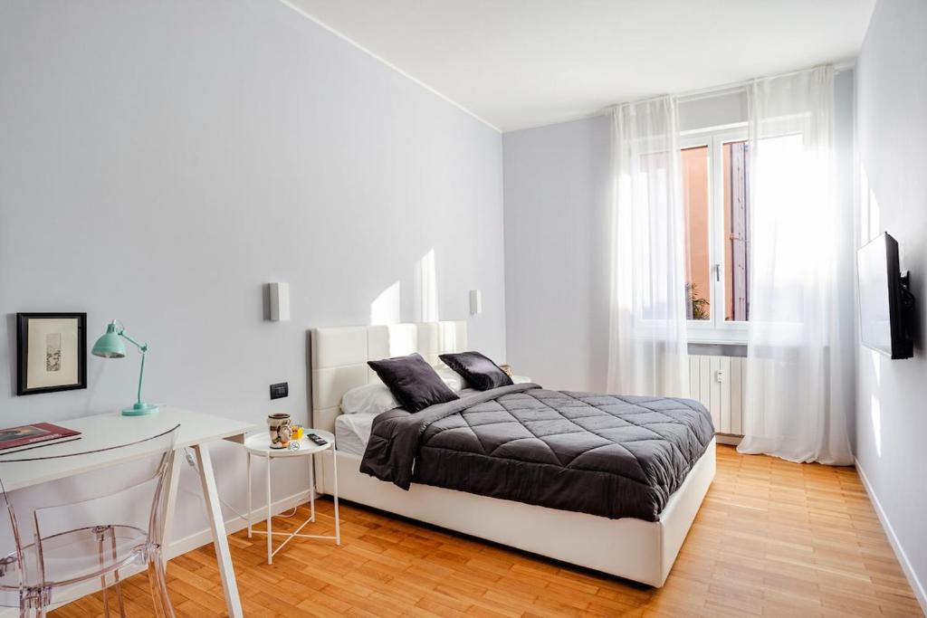 a white bedroom with a bed and a desk at Suite Andrea-Luxury Central Suite in Bergamo