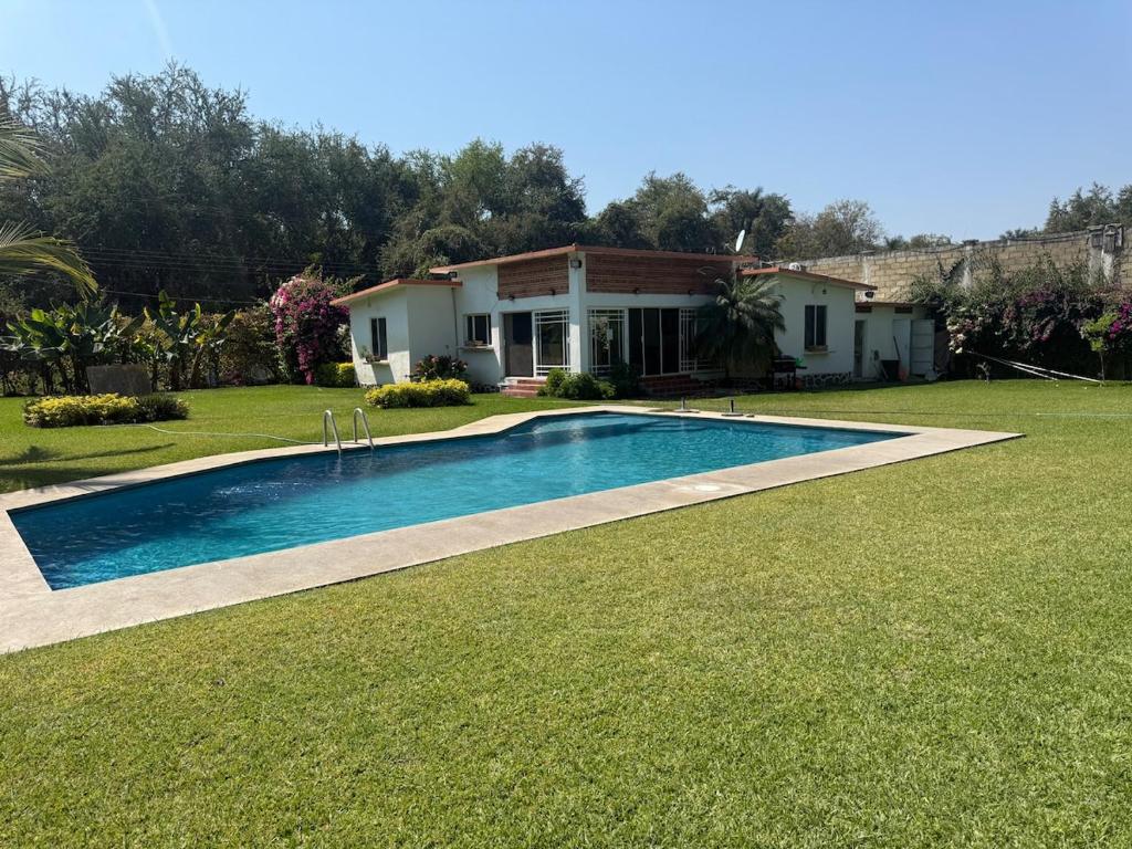 a swimming pool in the yard of a house at Casa Los Cardenales Ticuman in Ticumán