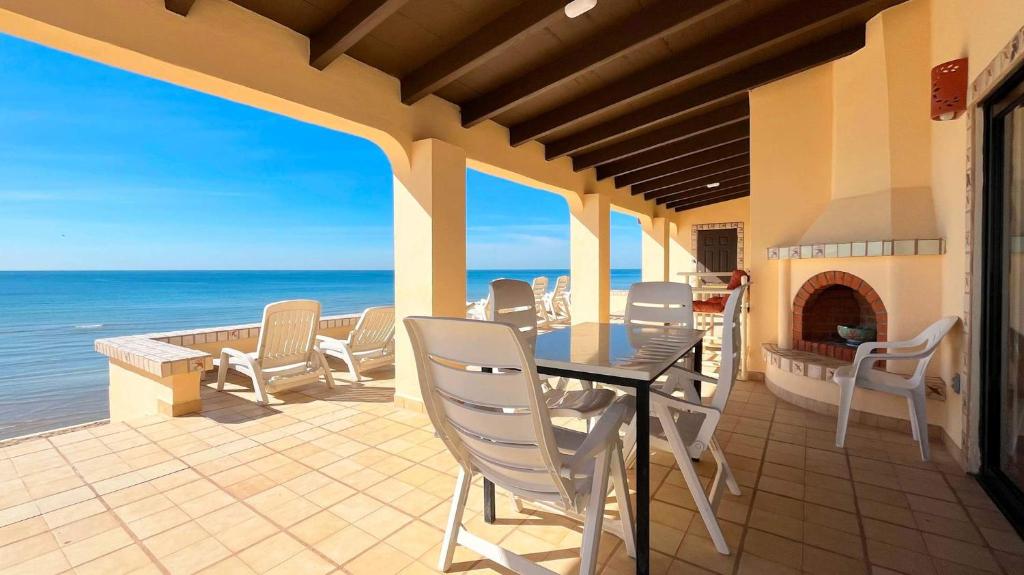 a patio with a table and chairs and the ocean at Charming 3-Bedroom Beachfront Home Bahia Delfin in Las Conchas