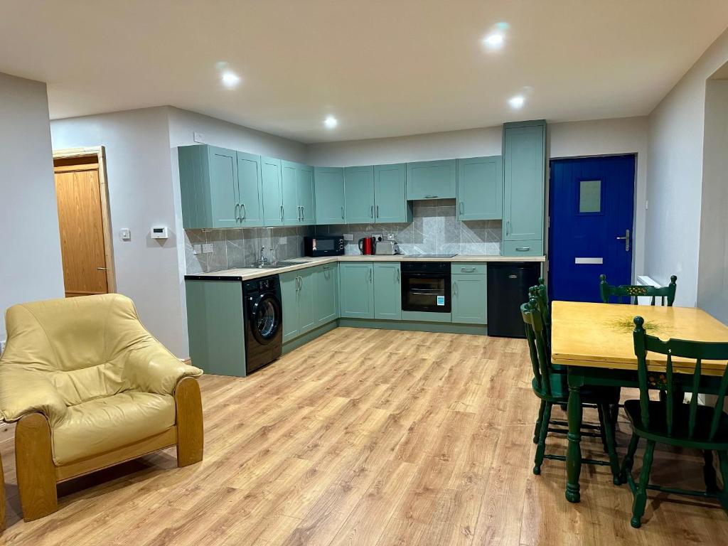 a kitchen with blue cabinets and a table and chairs at Ocean view apartment in Tralee