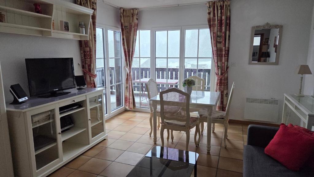 a living room with a television and a dining room table at Moléson Altitude in Moleson
