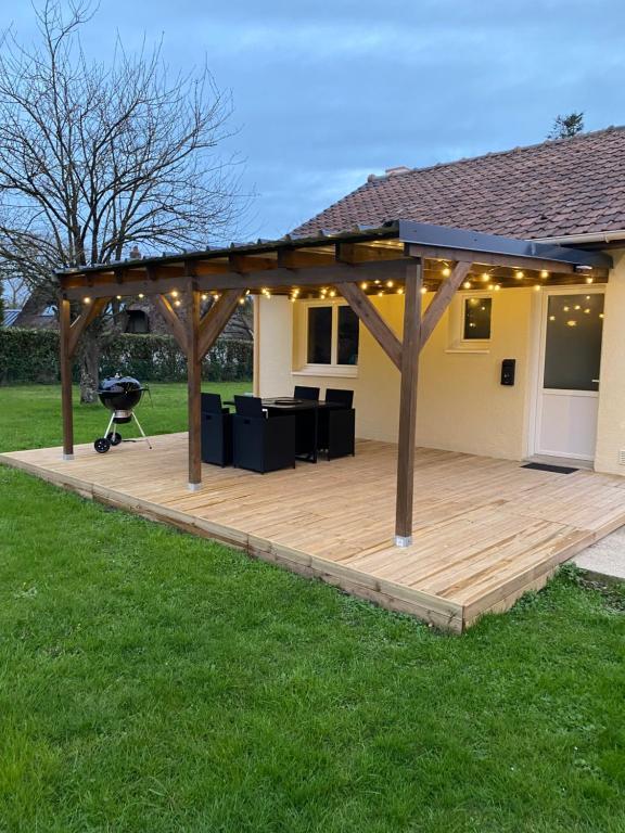 a pavilion with a grill on a wooden deck at Gîte la pause en baie in Pendé