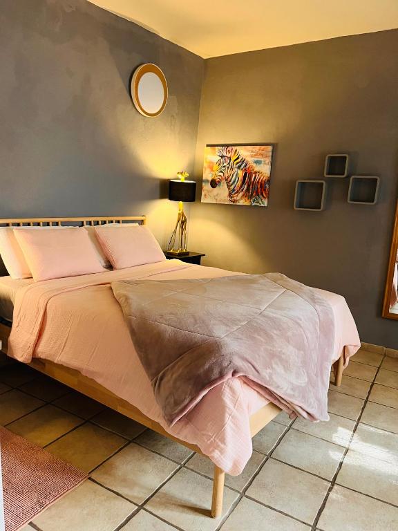 a bedroom with a large bed with pink sheets at Faro Town House in Faro