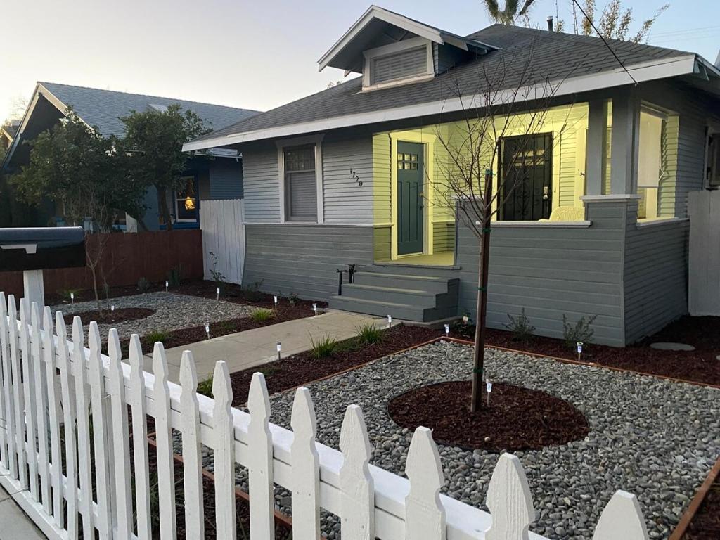 a white picket fence in front of a house at Classic California Bungalow Downtown in Bakersfield