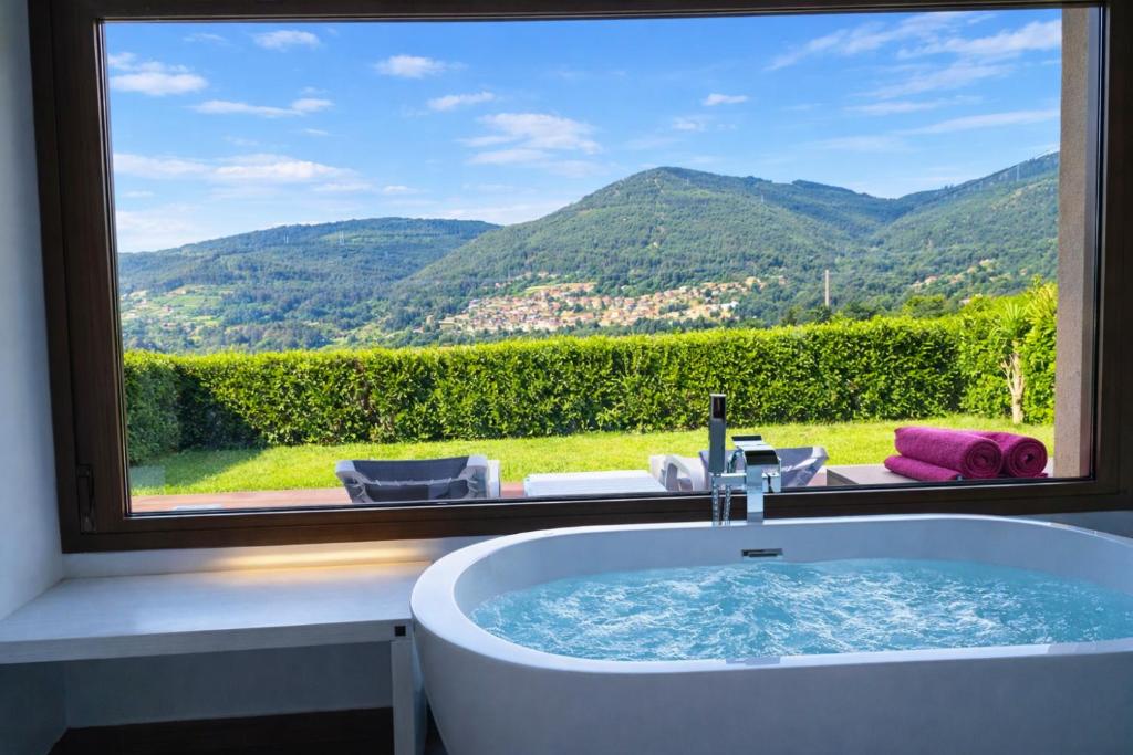 a bathroom with a bath tub in front of a window at Relax Natural en Vigo Rural Mos con Jacuzzi y Vistas in Mos