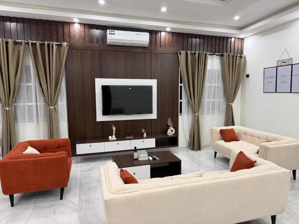 a living room with two couches and a tv at Appartement Kekely in Yovo Kopé