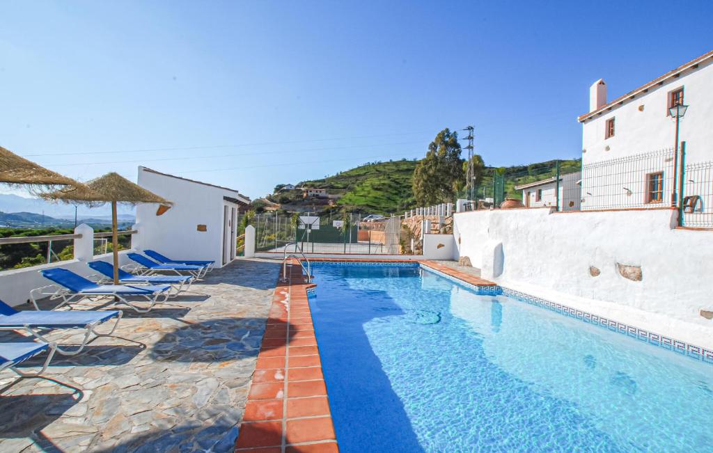 a swimming pool with chairs next to a building at El Pajar in Málaga