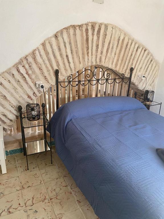 a bedroom with a large bed with a large headboard at Moreria Suites in Constantina