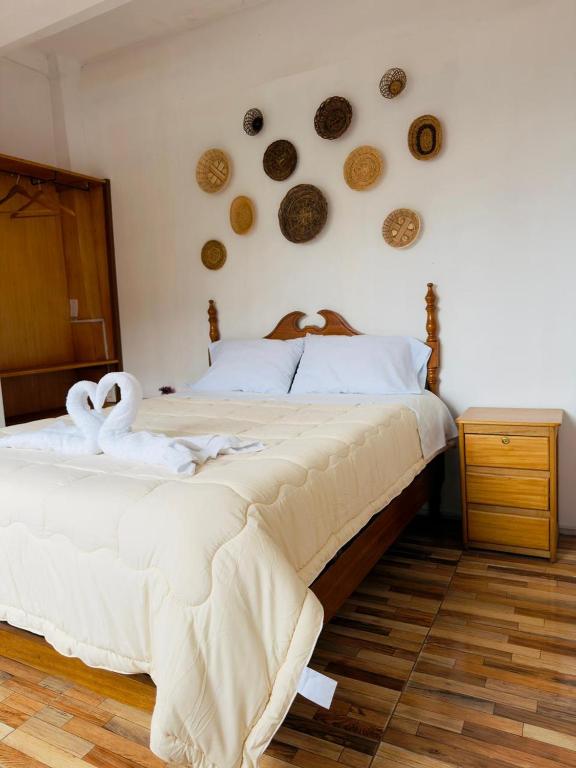 a bedroom with a bed with two swans on the wall at Big Vacation Hostel in Cusco