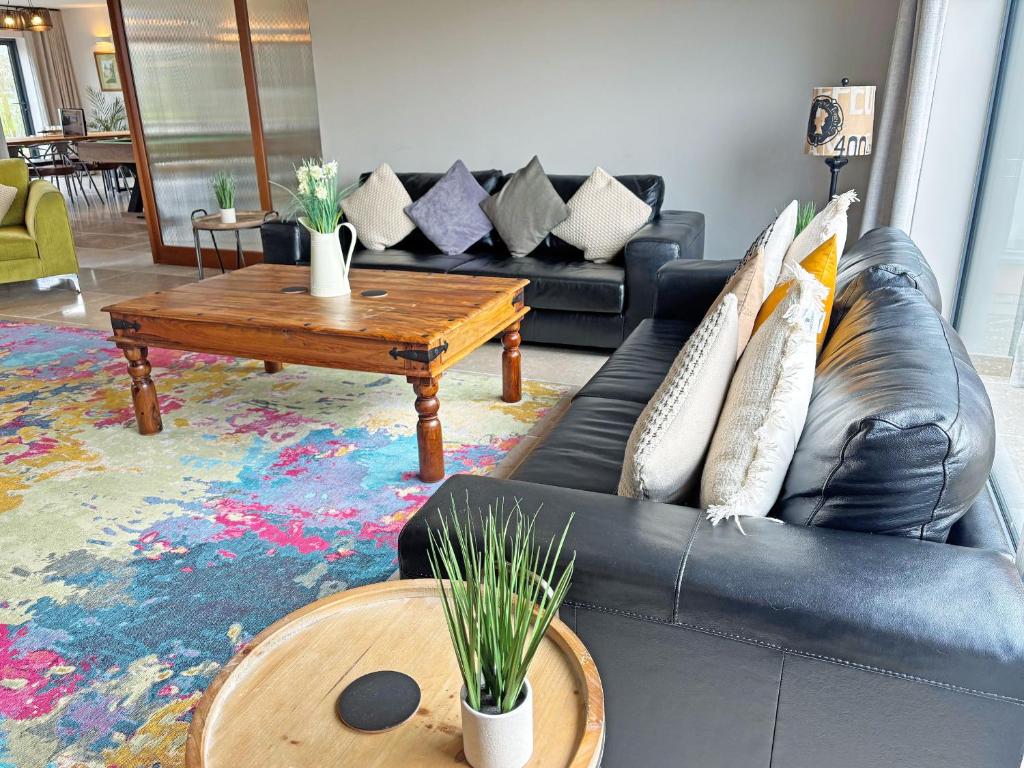 a living room with a black leather couch and a coffee table at Lime Tree House - Uk49477 in Bulmer