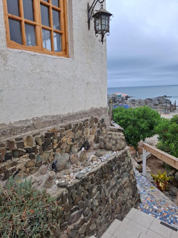 a building with a window and a stone wall at Casa de playa con espectacular vista in Islote Ramadas