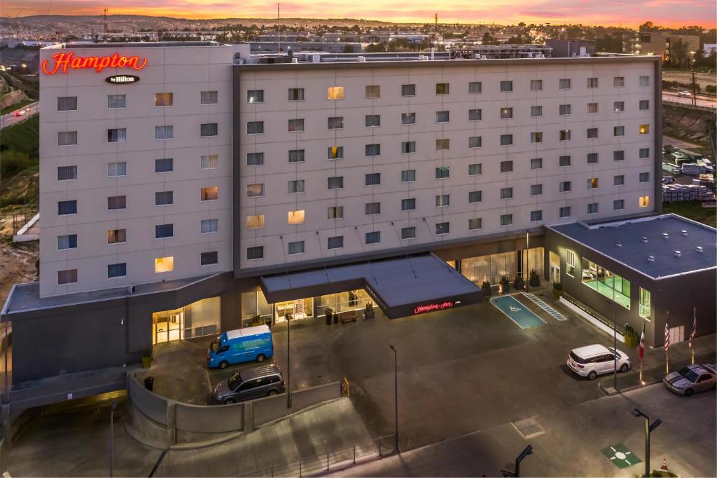 a large white building with a blue truck parked in a parking lot at Hampton Inn By Hilton Tijuana in Tijuana