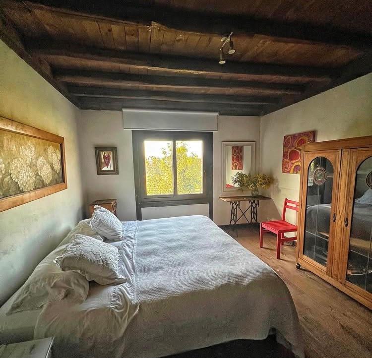 a bedroom with a large bed and a window at el corazón del cerro in Melipilla
