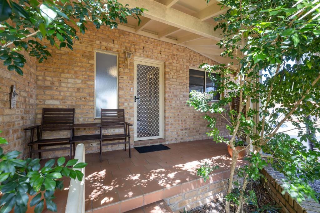 a patio with a table and chairs on a brick wall at Ocean Shores 1 in South West Rocks