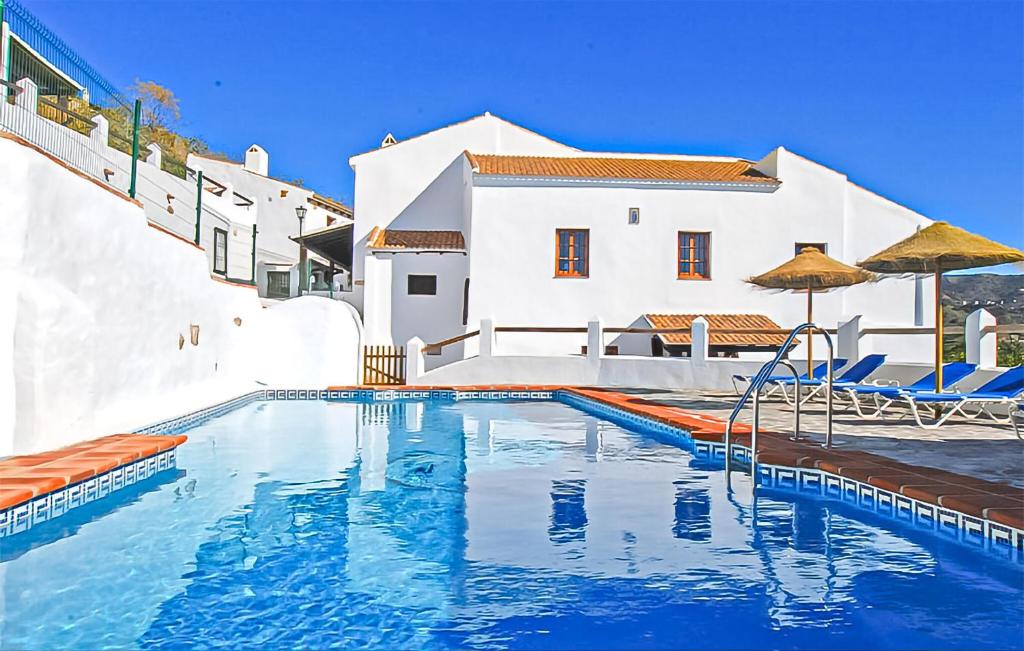 a swimming pool in front of a white house at La Cuadra in Málaga