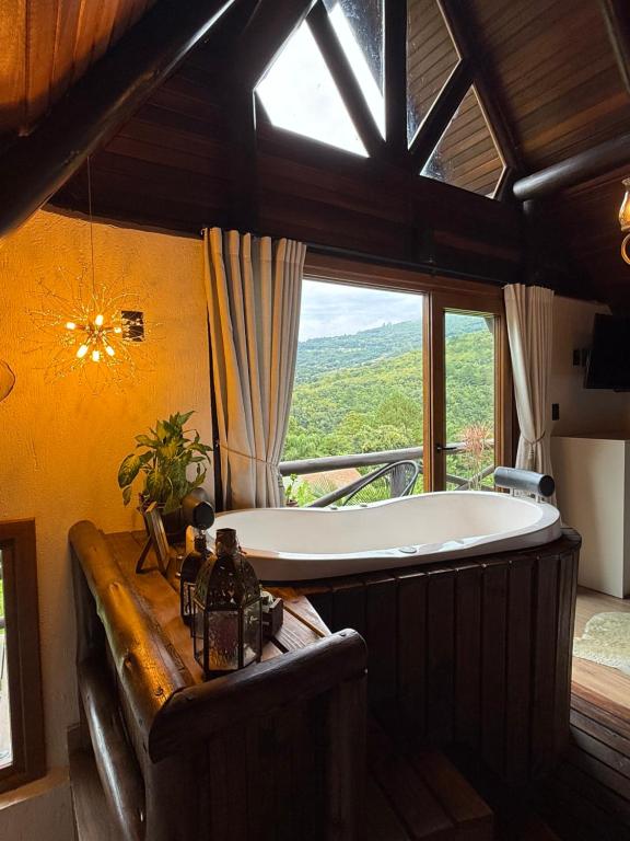 a large bath tub in a room with a window at Cabana Valle Pietra in Nova Petrópolis