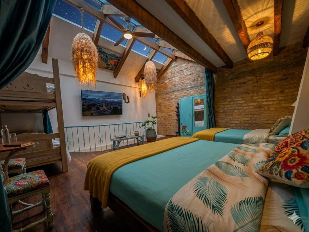 a bedroom with two beds and a brick wall at Cabaña tipo loft in Usaquén