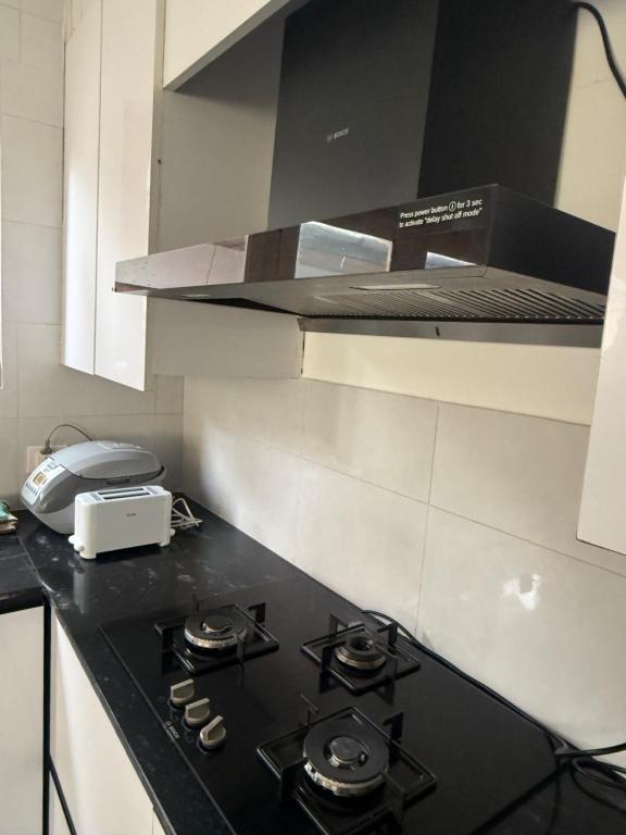a kitchen with a black stove top in a kitchen at Sompal Service Apartment in Paro