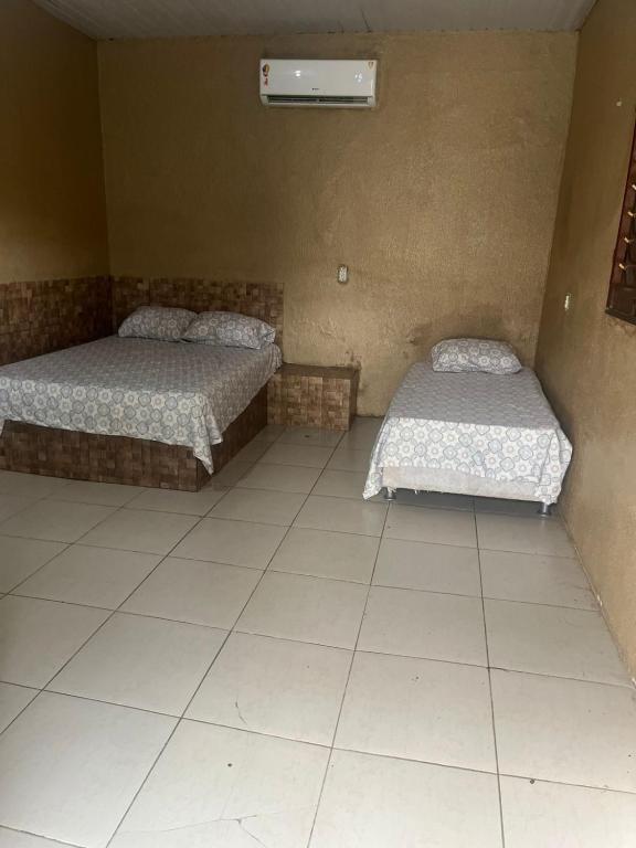 two beds sitting in a room with at Sitio Resenha in Caucaia
