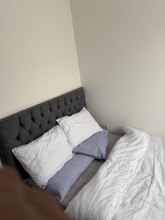 a bed with three pillows on it in a room at Holiday Haven in Potters Bar