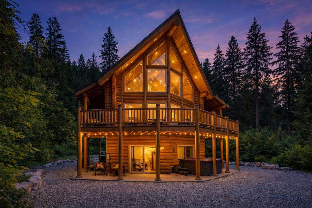 a cabin in the woods with large glass windows at Bearfoot Chalet by NW Comfy Cabins in Leavenworth