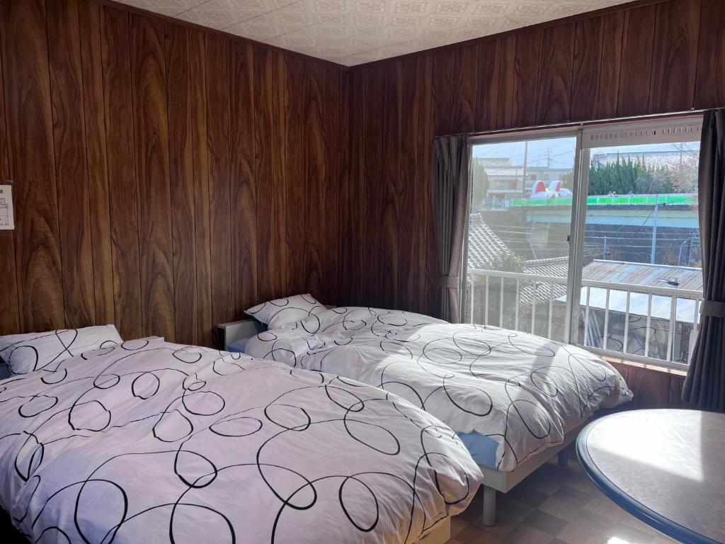 a hotel room with two beds and a window at Hillshouse2はなれ in Tokoname