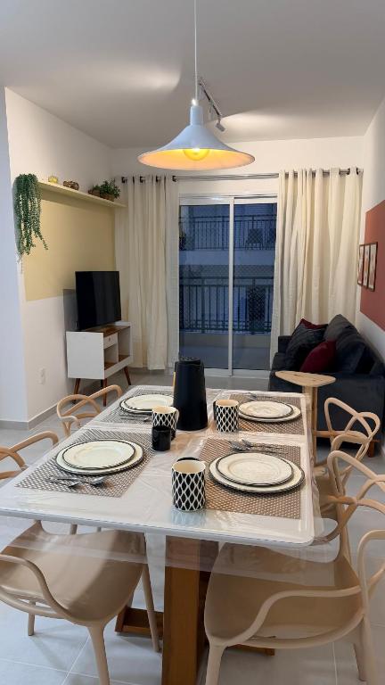 a living room with a table with plates and chairs at Mar e Natureza 2 quartos 6 Pessoas Lazer in Bertioga