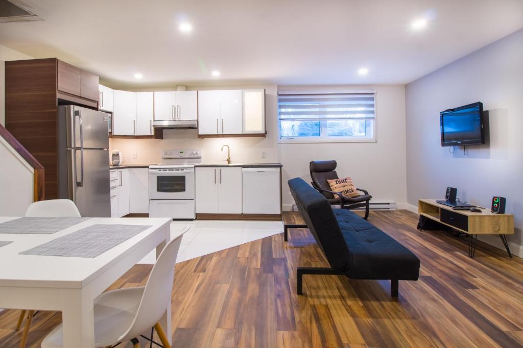 a kitchen and living room with a table and chairs at Appartement 2 chambres, centre ville, séjour longue durée in Quebec City