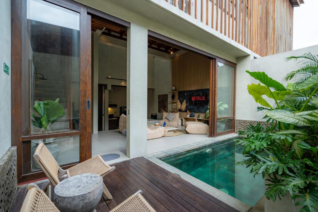 a villa with a swimming pool and a house at Unwind Villa by Betterplace in Canggu