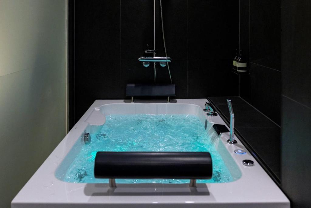 a bathroom with a bath tub with blue water at Anook Hotel Incheon Bupyeong in Incheon
