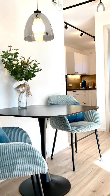 a dining room table with two chairs and a vase with a plant at Alpen Liebe Prem in Prem