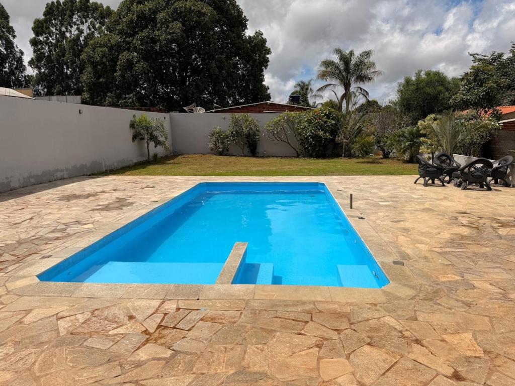 a large blue swimming pool in a yard at Recanto do boto in Anápolis