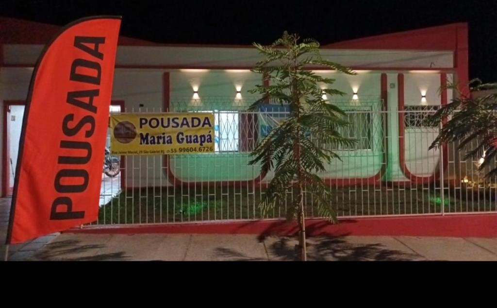 a sign on a fence in front of a building at Pousada Maria Guapa 2 in São Gabriel