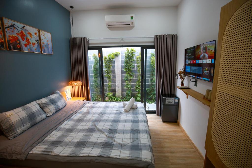 a bedroom with a bed and a large window at Trăng Non Homestay in Phan Thiet