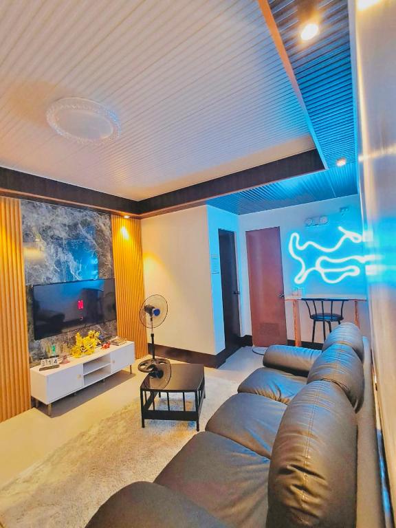 a living room with a couch and a large tv at ErrZ Homestay in Malaybalay in Malaybalay