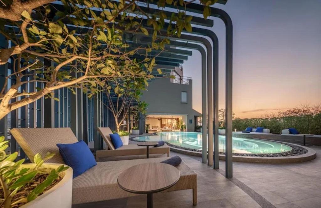 eine Außenterrasse mit Pool, Tischen und Stühlen in der Unterkunft Casa 17 Hotel Bangkok in Bangkok